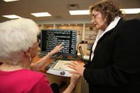 One woman showing another woman a desktop magnifier